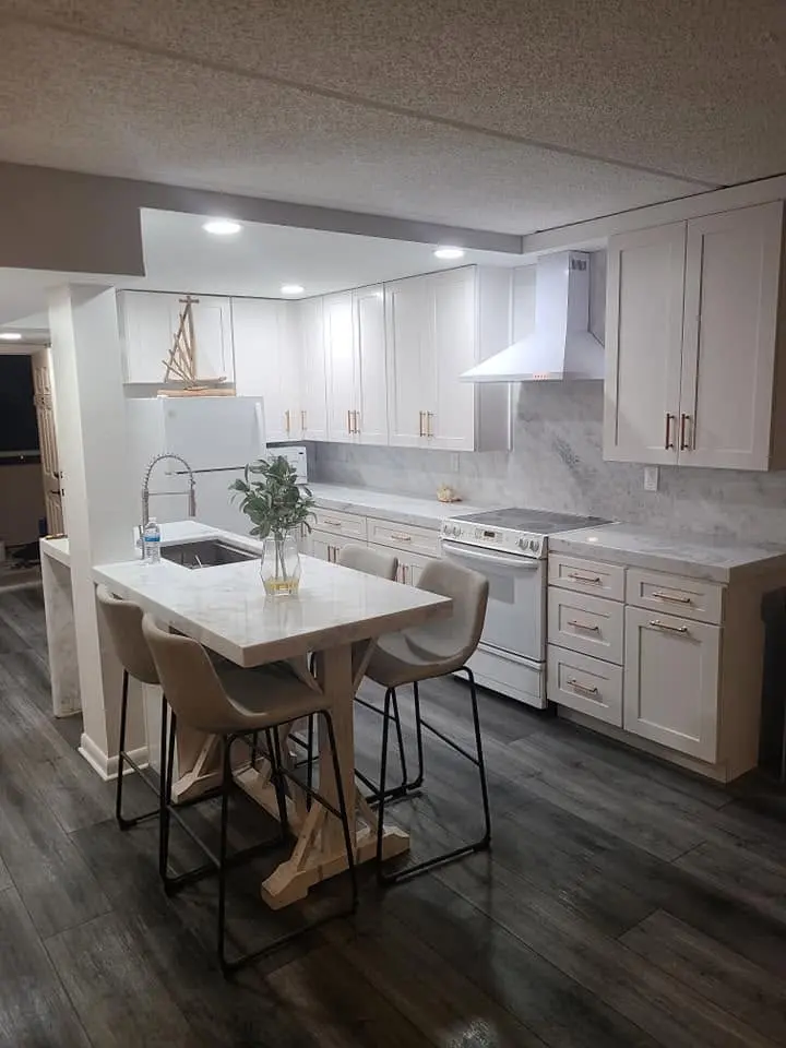 Remodeled white kitchen with quartz countertops, tile backsplash and dining nook