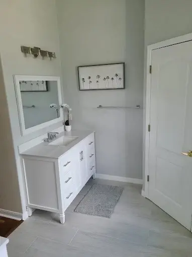 Guest bathroom with new white vanity, framed mirror and vanity lighting