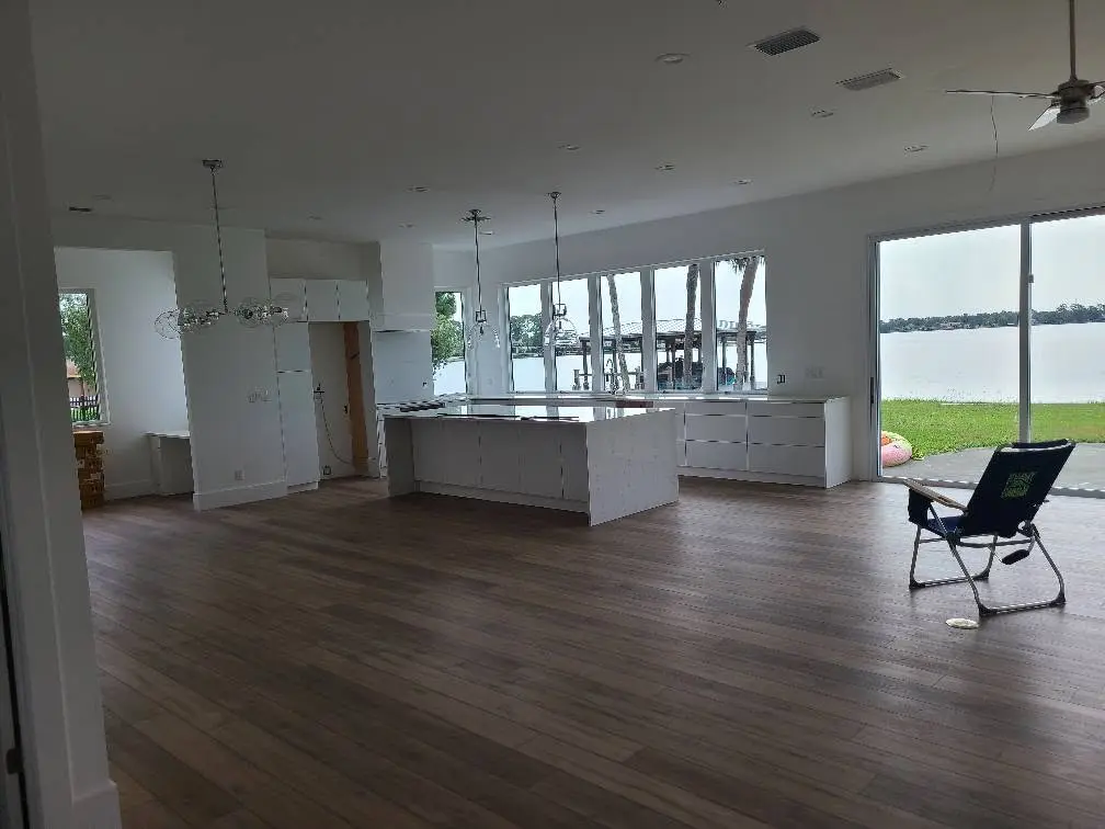 Open-concept living room after remodel with wood-look luxury vinyl plank flooring and lake views