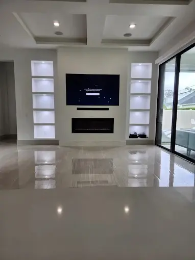 Living room with built-in linear fireplace wall, display niches and polished tile floor